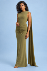 Lang, figurnær grønn kjole med båthals, capeermer og åpen rygg